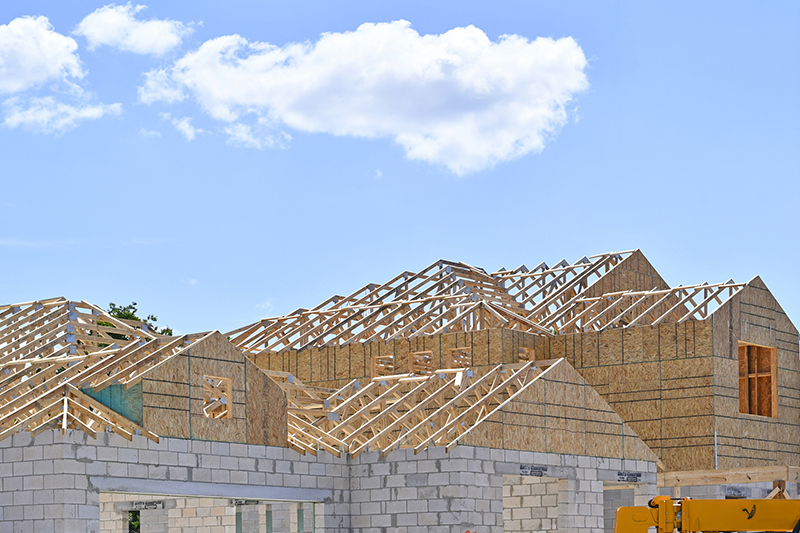 Incomplete new two story residential home under construction at wood frame under blue skies in central Florida